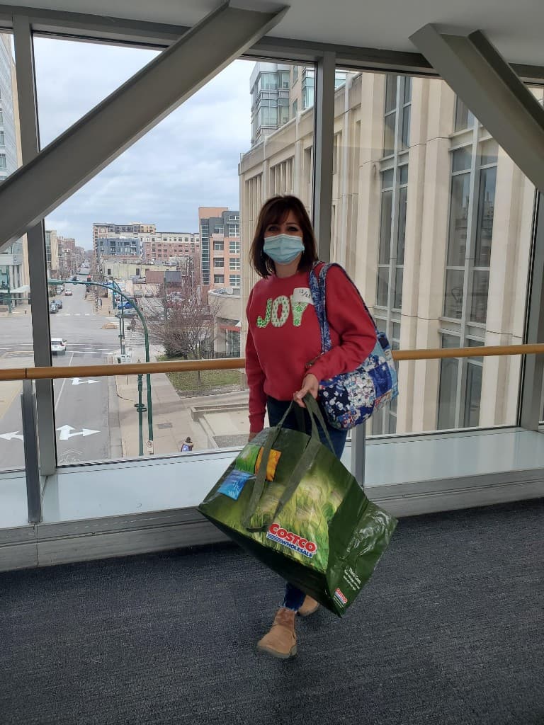 A family member carrying blankets through a hospital.